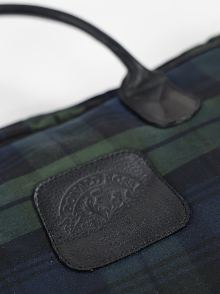 Close-up of a plaid bag with dark green and navy blue checkered pattern