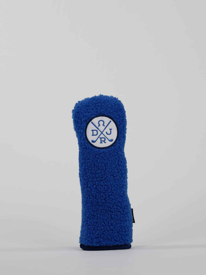 A blue, textured golf club headcover with a white circular logo displaying crossed golf clubs