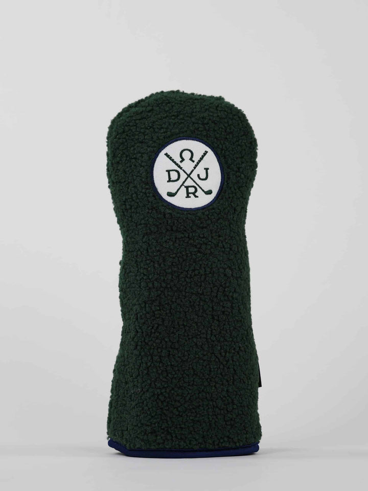 Dark green textured golf club headcover with a white circular patch displaying crossed golf clubs and letters