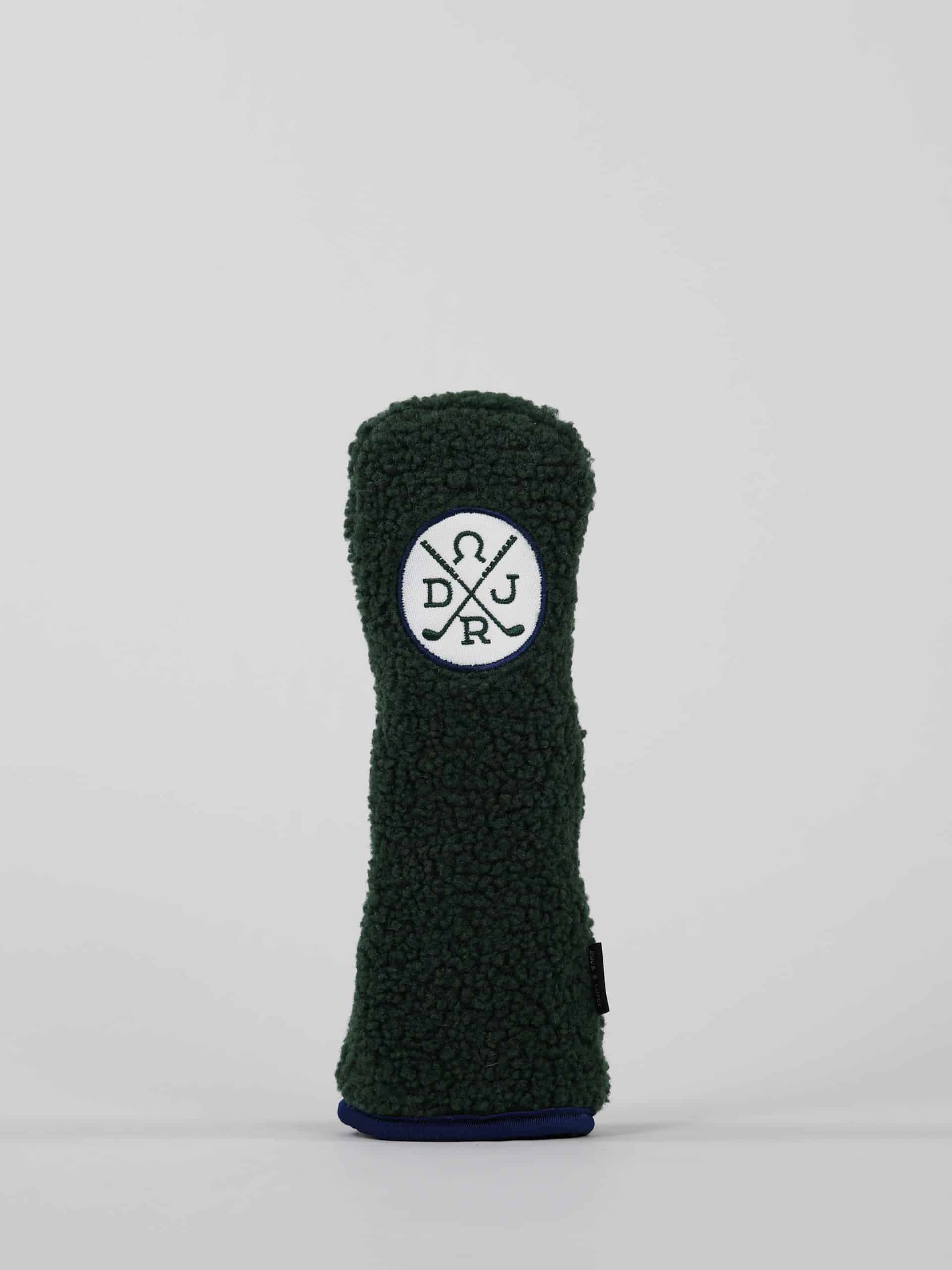 Dark green, textured golf club headcover with a circular logo featuring crossed lines and letters