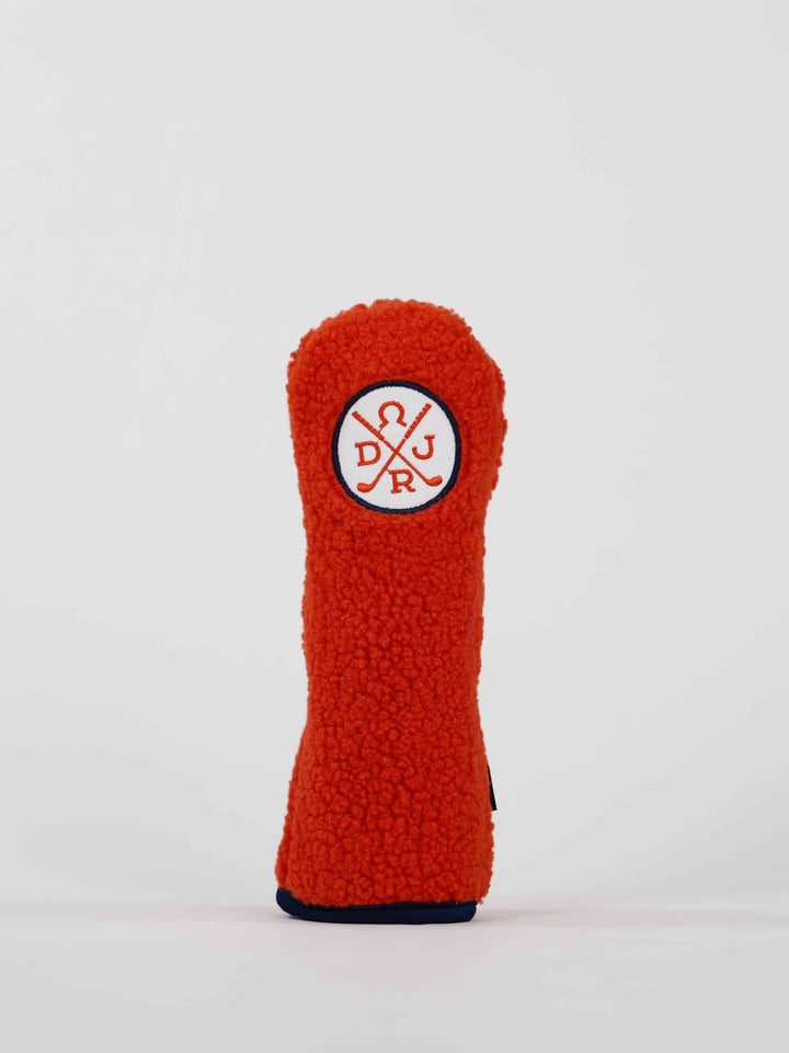 Bright orange, fluffy golf club head cover with a stitched logo of intersecting golf clubs