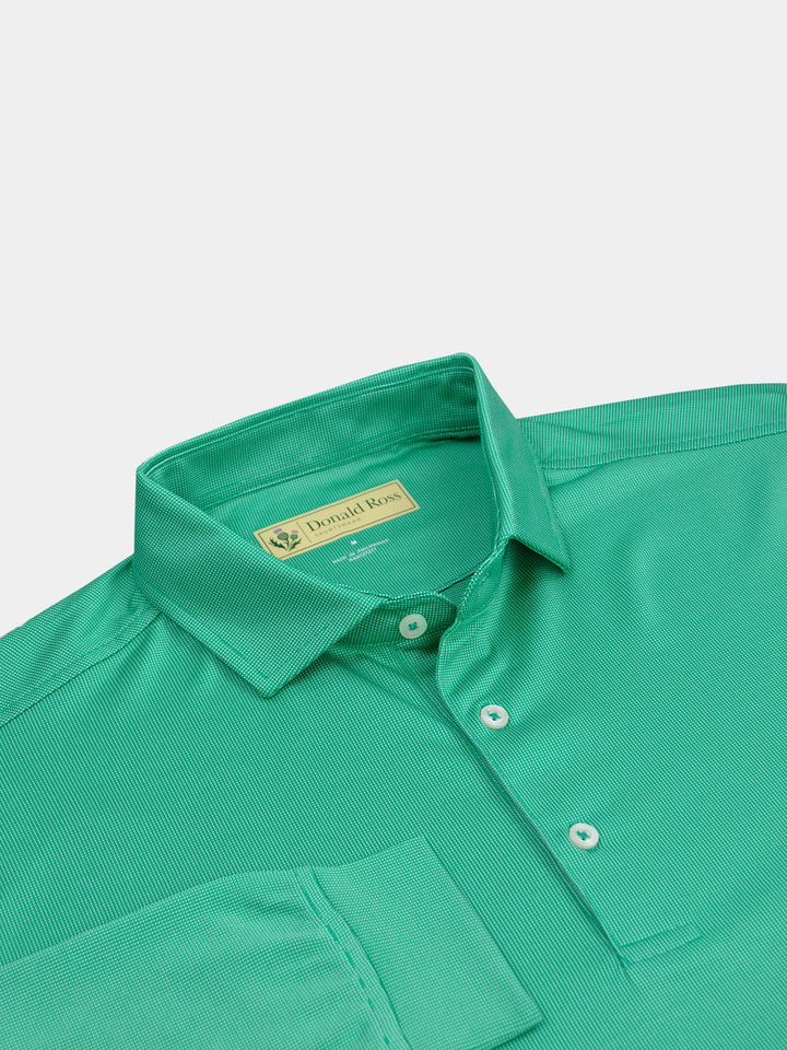 Green textured polo shirt with a structured collar and three white buttons. The sleeve of the shirt is laid over the front of the shirt