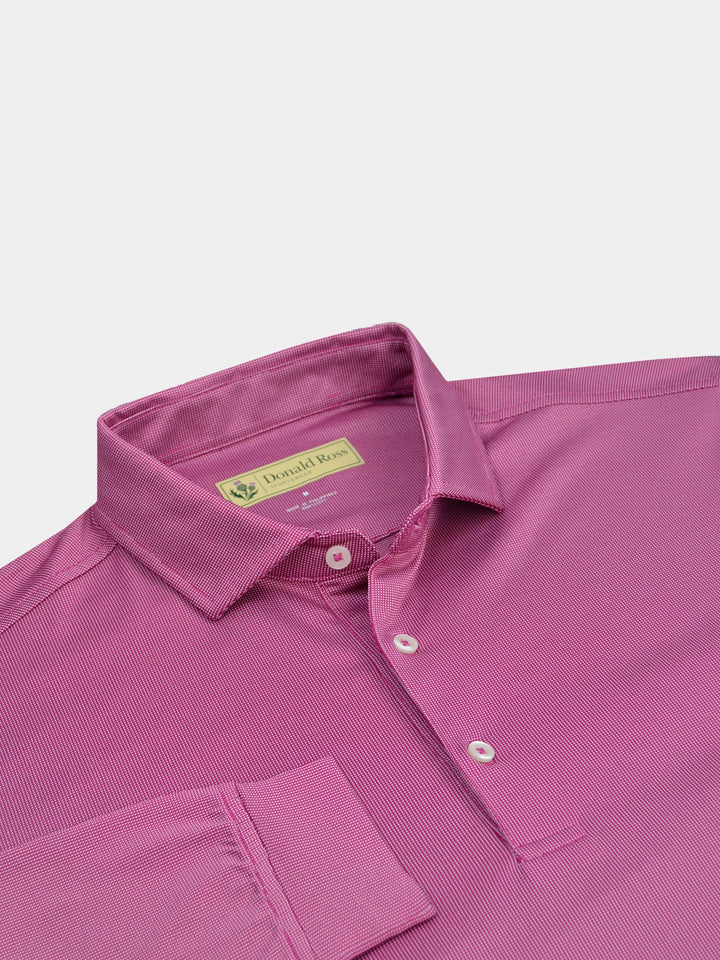 Pink short-sleeve golf polo shirt with a collar and three buttons, laying flat