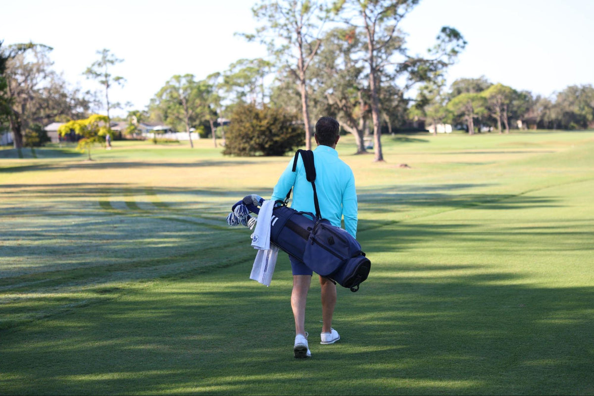 A man walking on a golf course wearing Donald Ross Sportswear