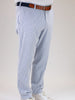 Man in blue and white striped pants, white shirt, and brown belt. White sneakers complete the casual yet stylish look.