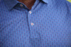 Close-up of a blue cotton button-up shirt with a fine red and white geometric pattern and mother-of-pearl buttons.