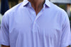 Man wearing a short-sleeved button-up shirt in blue with an allover geometric pattern.