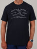 A man is wearing a dark navy t-shirt featuring white text promoting golf course design and architecture.