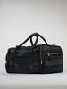A stylish plaid duffel bag with black leather accents and multiple zippered compartments