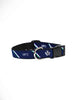 A blue dog collar with diagonal green, purple, and white stripes