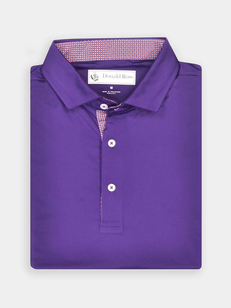 A neatly folded, vibrant purple polo shirt with a patterned inner collar is displayed against a light background
