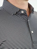 Close-up of a golfer wearing a black and white striped polo shirt with a button-down collar