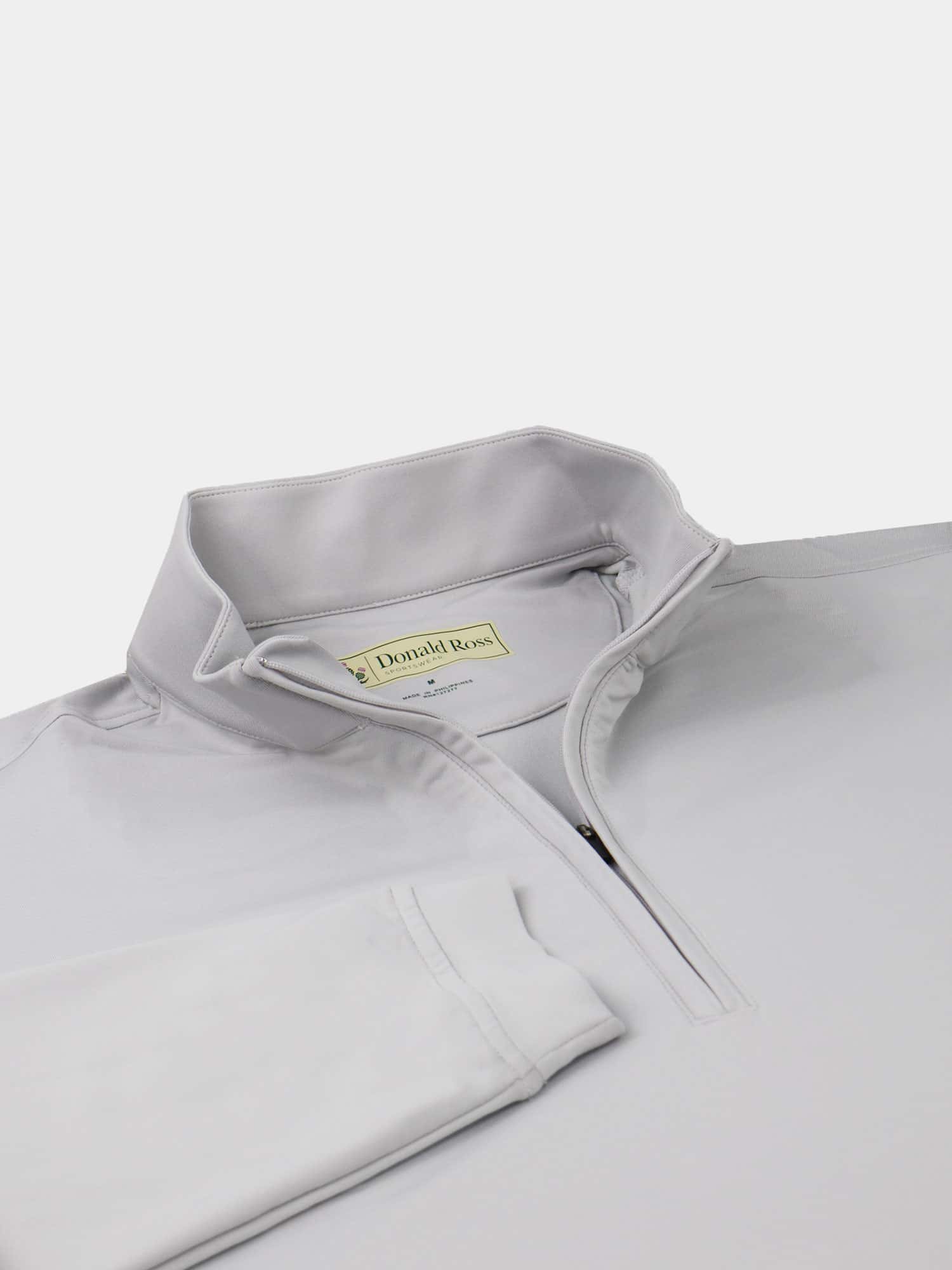 A light gray quarter-zip golf pullover with a folded collar, laid flat