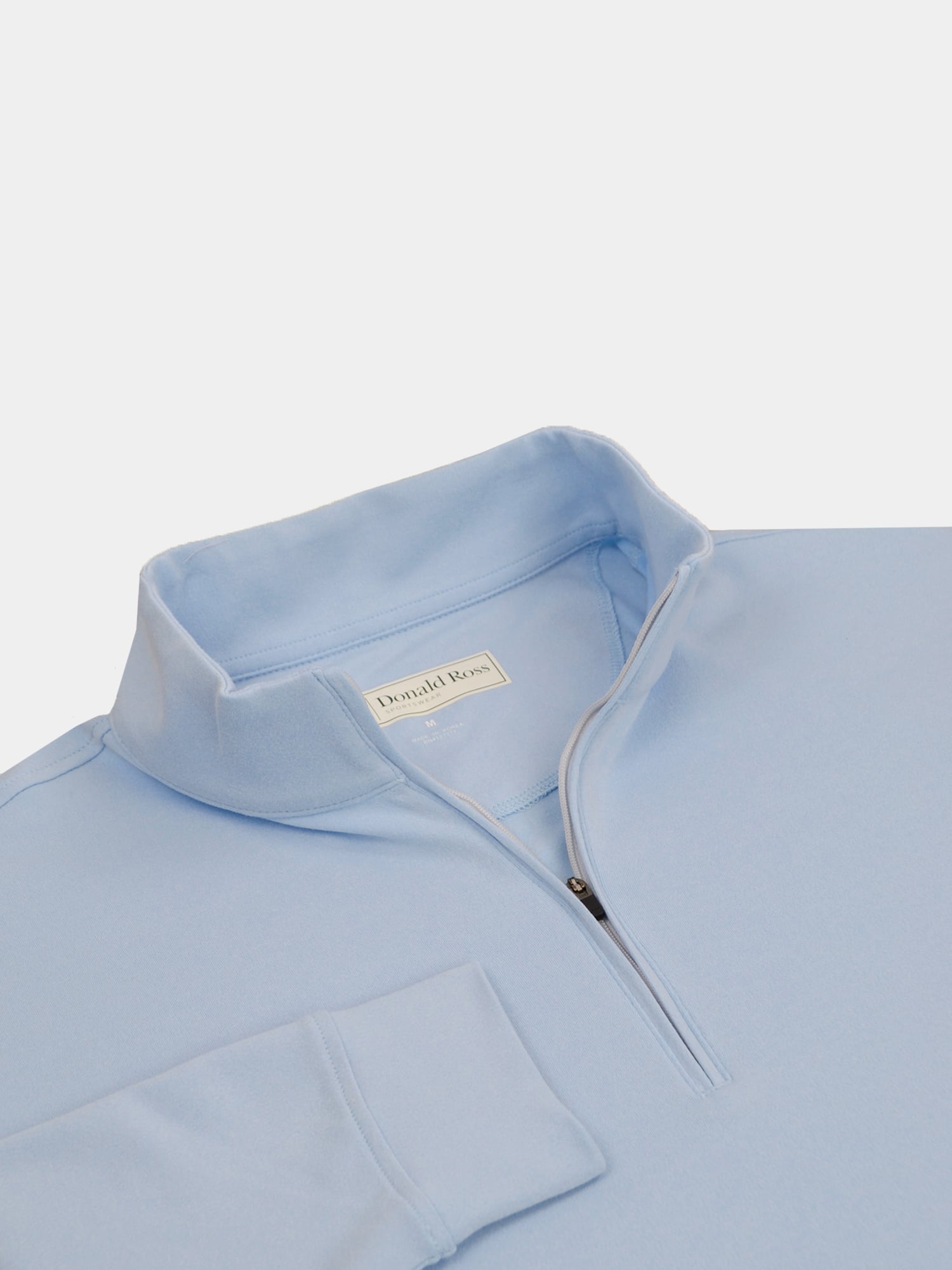 Light blue quarter-zip fleece sweatshirt with a folded collar, partially unzipped. The fabric appears soft, conveying comfort and casual style.