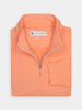 Folded orange half-zip pullover, made of soft performance fabric for golfing enthusiasts