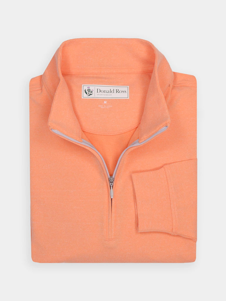 Folded orange half-zip pullover, made of soft performance fabric for golfing enthusiasts