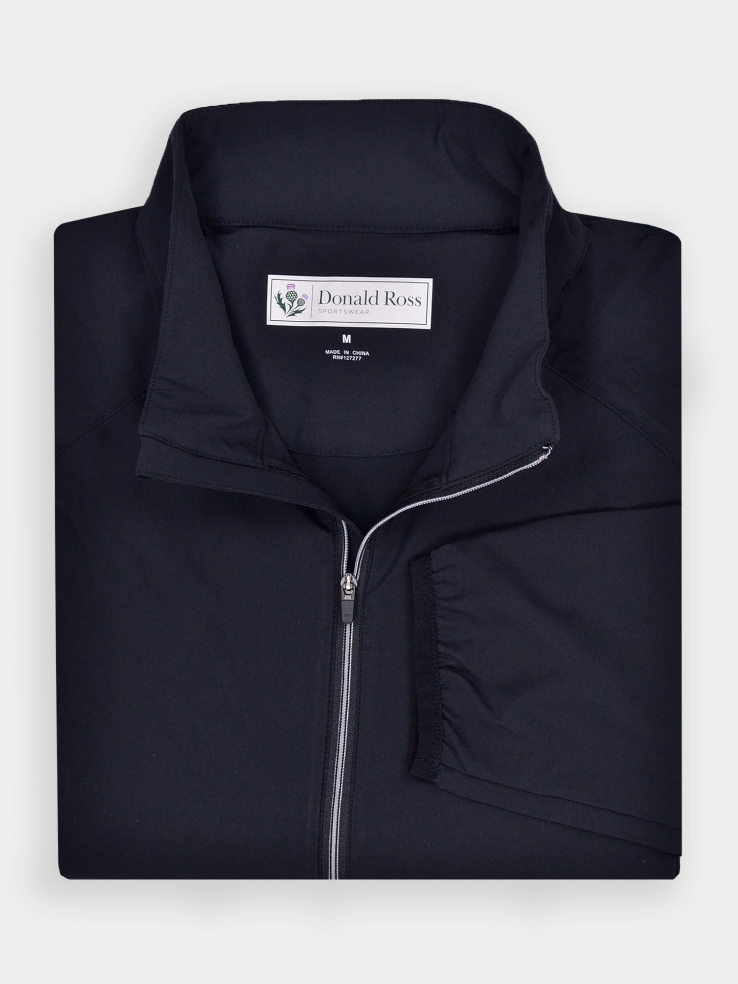 Folded black wind shell jacket with a standing collar, perfect for layering on windy days