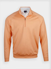 Orange quarter-zip pullover on display. It features a simple design with long sleeves and a collar pulled over a white golf polo shirt
