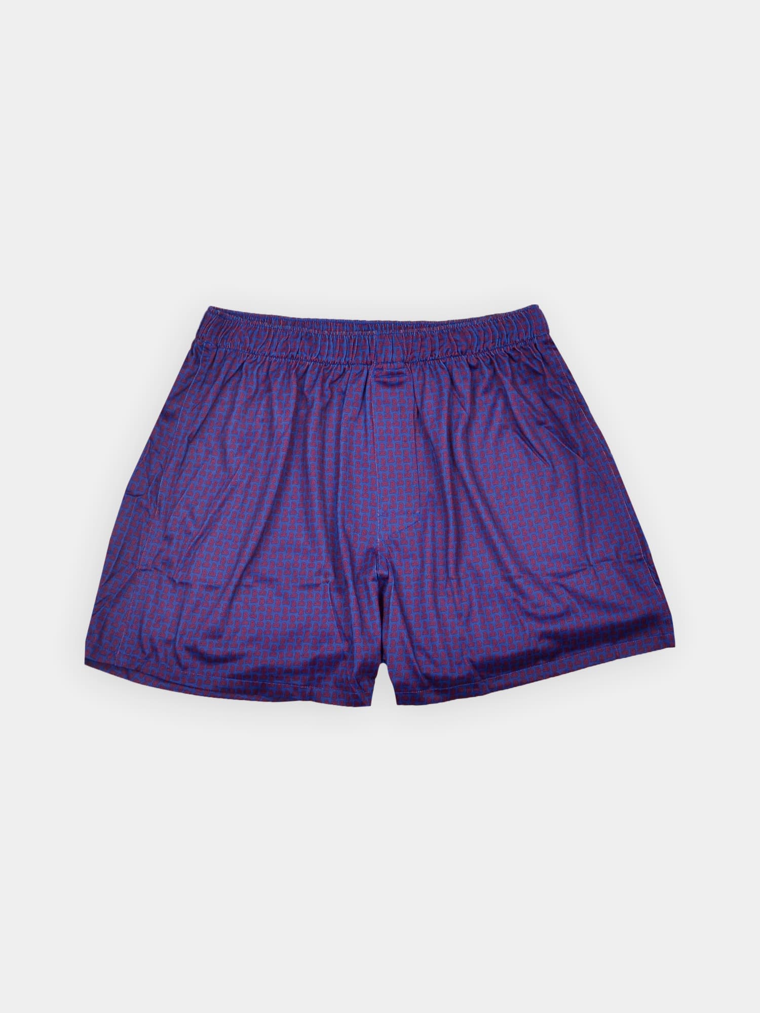 Purple paisley boxer shorts with an elastic waistband, laid flat on a white background