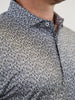 Close-up of a person wearing a black and white flame patterned shirt with intricate swirl designs. The look is stylish and sophisticated.