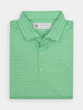 Folded green polo shirt with a small dark green peppers pattern. Features white buttons with blue accents