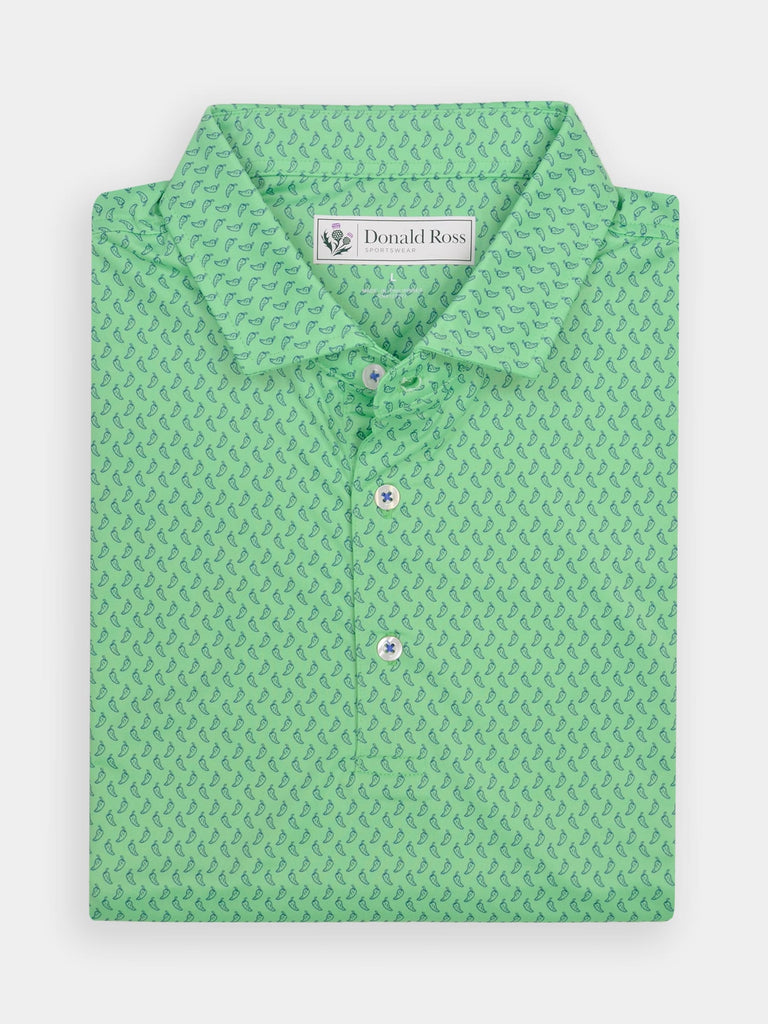 Folded green polo shirt with a small dark green peppers pattern. Features white buttons with blue accents