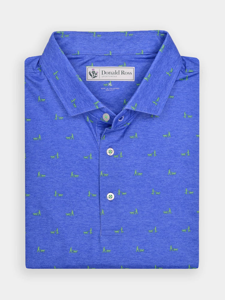 Folded blue polo shirt with small green dogwalker patterns, buttoned collar, and a tag on the inside