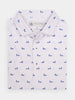 Folded white polo shirt featuring a repeated pattern of small blue dog walker silhouettes
