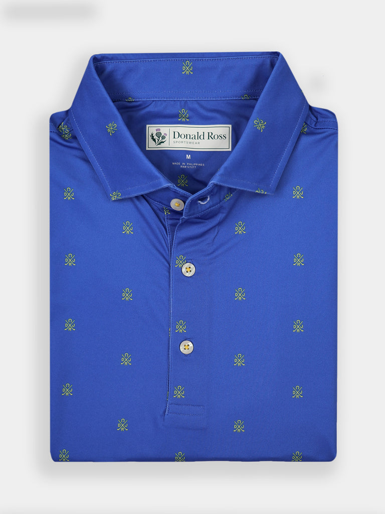 Folded blue polo shirt with small green embroidered patterns, featuring a neat collar and three buttons