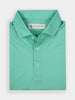 Folded green polo shirt with a subtle geometric pattern, featuring buttons and a collar