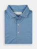 Folded blue polo shirt with a subtle geometric pattern, featuring a branded label inside the collar and three buttons down the front