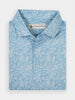 Folded blue floral polo shirt with white buttons, featuring a subtle white flower pattern and a small label under the collar. Bright and stylish.