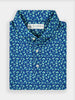 Folded blue collared golf polo shirt with a vibrant floral green palm leaf pattern