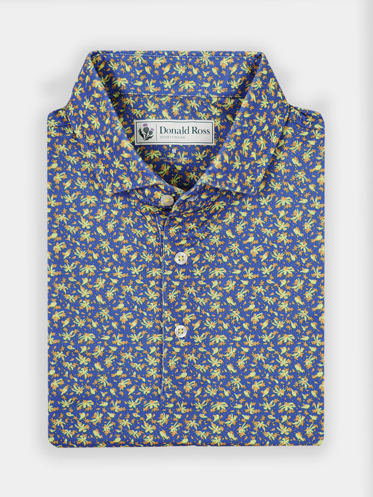 Folded blue shirt with a vibrant yellow floral pattern. White buttons adorn the front, with a Donald Ross Sportswear logo