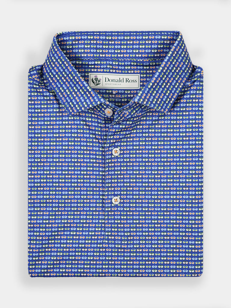 Folded blue shirt with a small white and yellow sunglasses pattern, featuring a collar and white buttons
