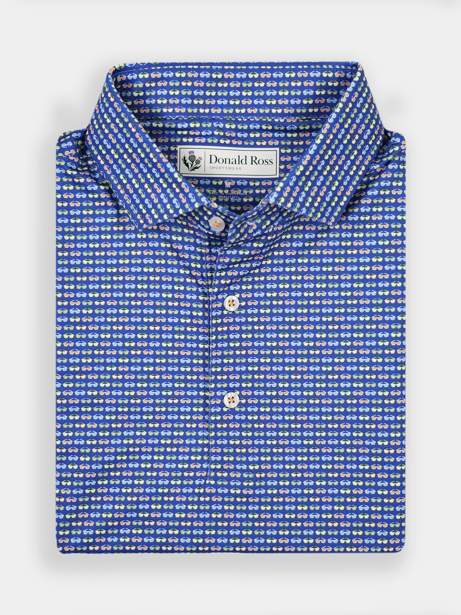 Folded blue shirt with a small white and yellow sunglasses pattern, featuring a collar and white buttons
