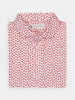 Folded short-sleeve shirt with a small pink and red floral pattern on a white background, portraying a fresh and cheerful vibe.