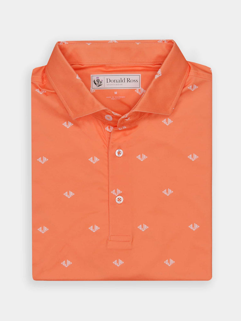Bright orange polo shirt with a folded collar and buttoned placket, featuring a subtle, repeating white logo pattern.