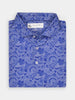 A folded blue paisley shirt with intricate white patterns, featuring a button-down collar and buttons. The shirt conveys a classic and elegant style.