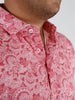 Close-up of a person wearing a red paisley-patterned shirt, showcasing intricate white designs.