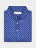 Folded blue shirt with small white royal patterns, featuring a buttoned collar and visible brand label. The design conveys a formal and stylish tone.