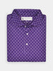 Folded purple polo shirt with a small white royalty pattern, featuring a label at the collar. The shirt's neat folds convey a sense of elegance and style.
