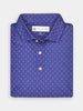 Folded blue polo shirt with a royalty pattern on a white background. The shirt features white buttons and a collar.
