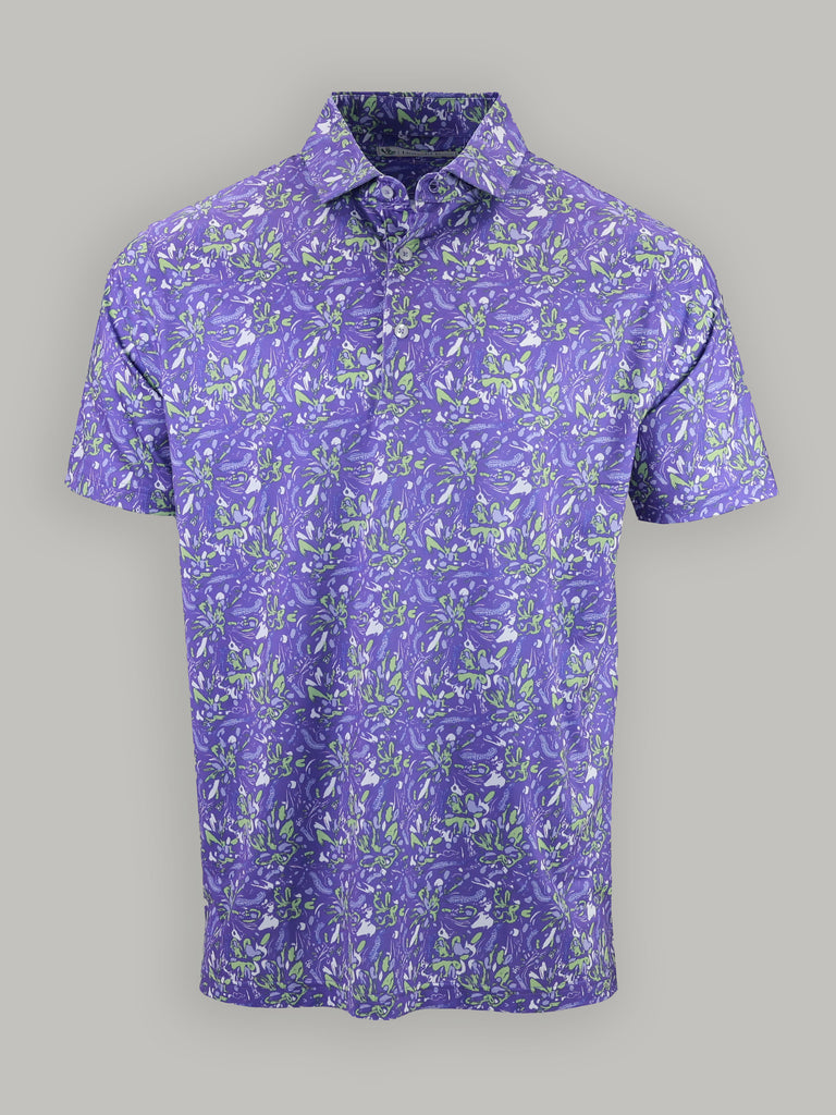 Purple short-sleeve shirt with vibrant green and white floral patterns on a plain gray background, conveying a summery, lively tone.