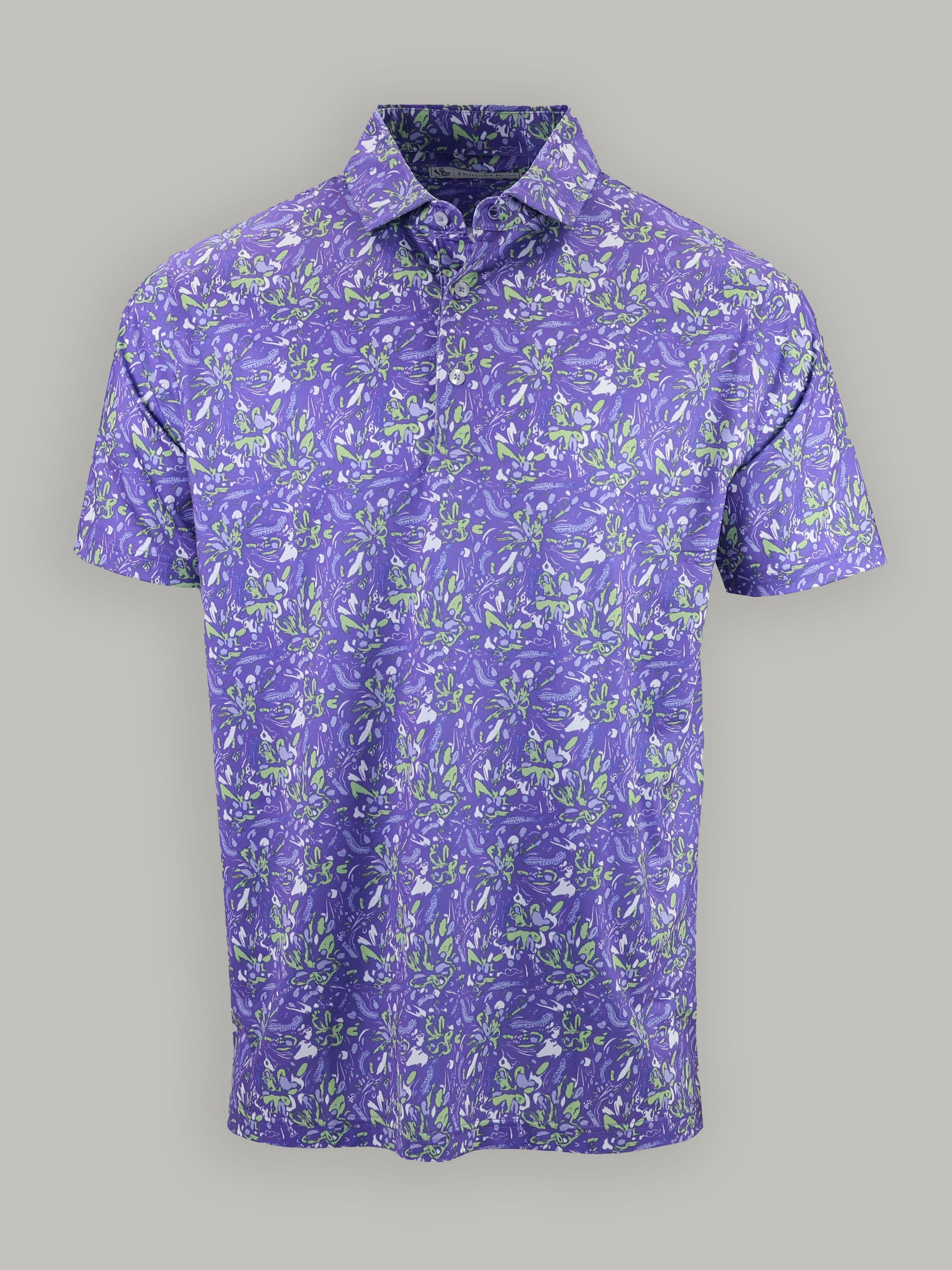 Purple short-sleeve shirt with vibrant green and white floral patterns on a plain gray background, conveying a summery, lively tone.
