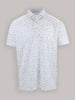 A white polo shirt with a subtle abstract pattern of small scattered golf tees in blue, green, and purple. It has a classic collar and short sleeves.