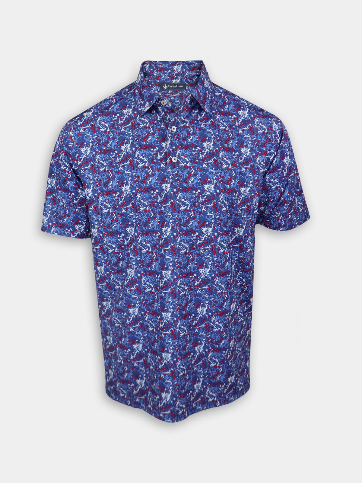 A short-sleeved men's shirt with a vibrant blue, white, and red abstract paint splatter pattern, featuring a collared neckline and button-down front.