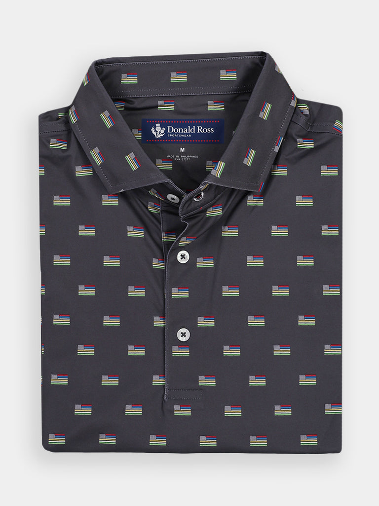 Dark gray button-up shirt folded neatly, adorned with a repeating pattern of small flags. The label reads "Donald Ross Sportswear." The shirt conveys a polished, casual style.