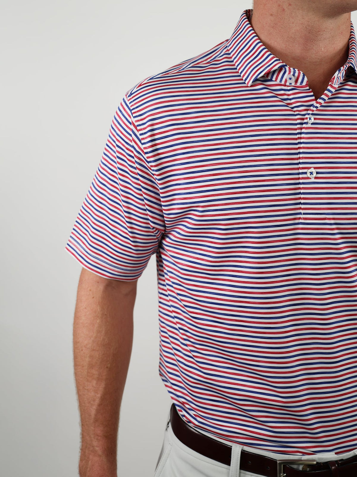 Man wearing a red, white, and blue striped polo shirt with short sleeves