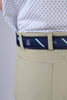 Close-up of a person wearing beige trousers, a navy belt with green and white stripes, and a patterned white shirt